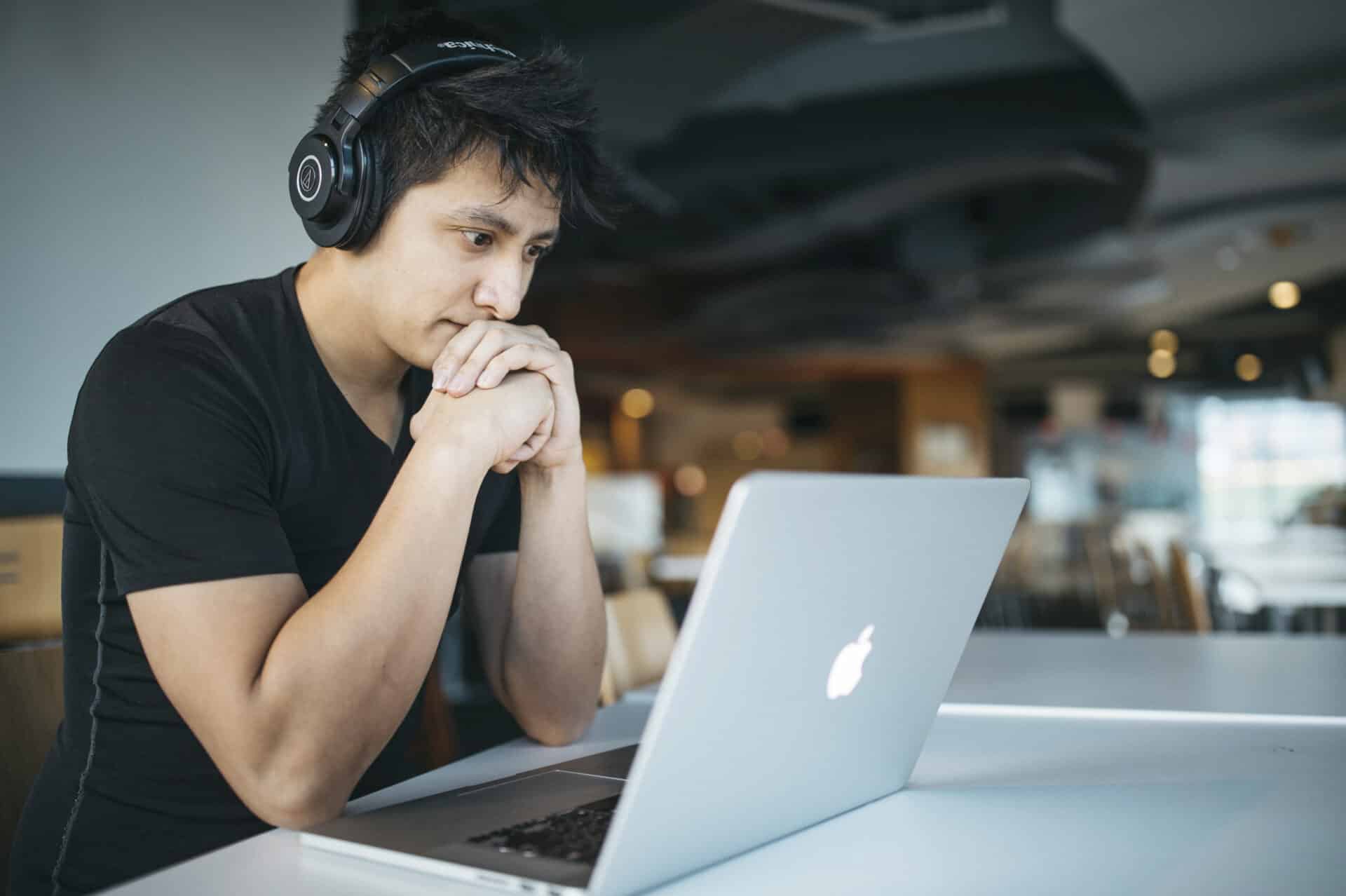 student w słuchawkach przed laptopem